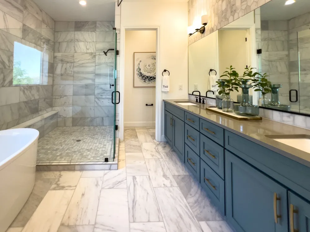 Modern mid-range bathroom remodel with walk-in shower, vanity, tile flooring and updated lighting