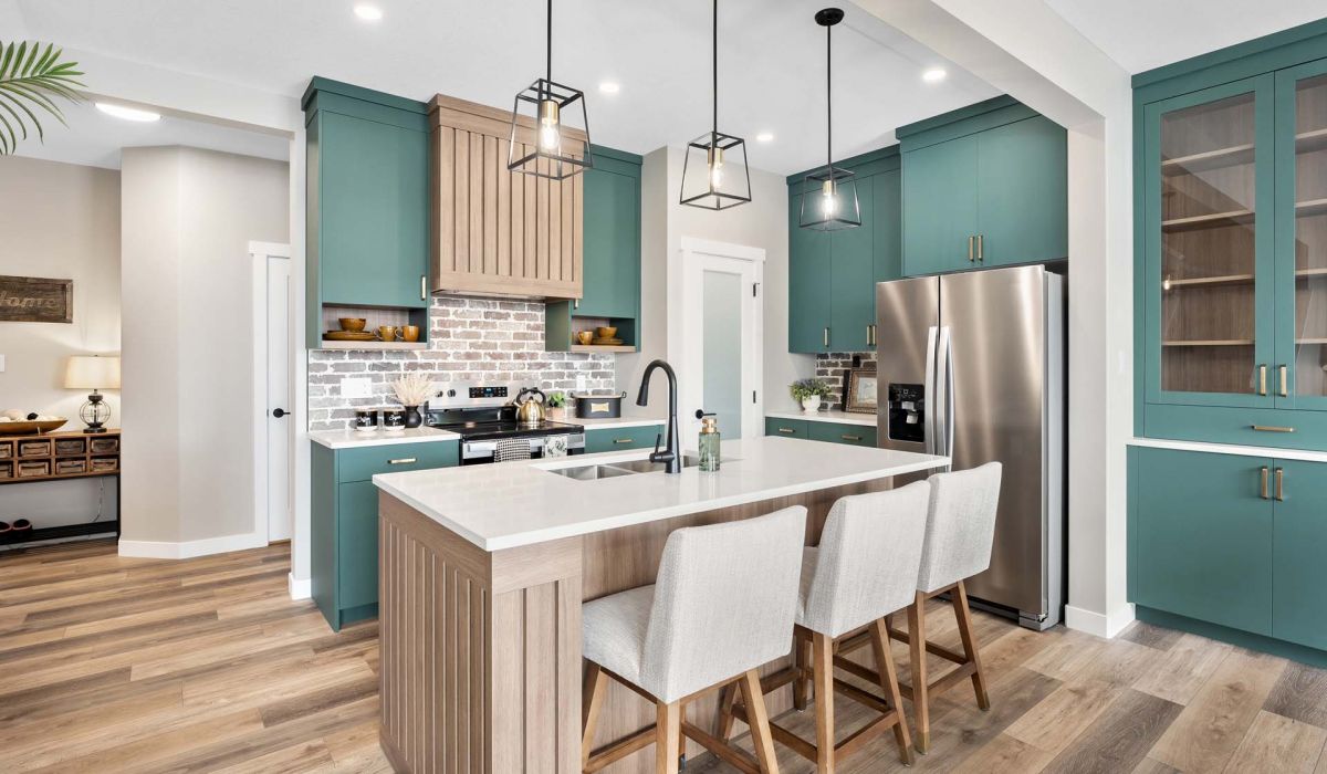 Kitchen with a white island and blue cabinets. The kitchen has a modern feel with a lot of light and a lot of white
