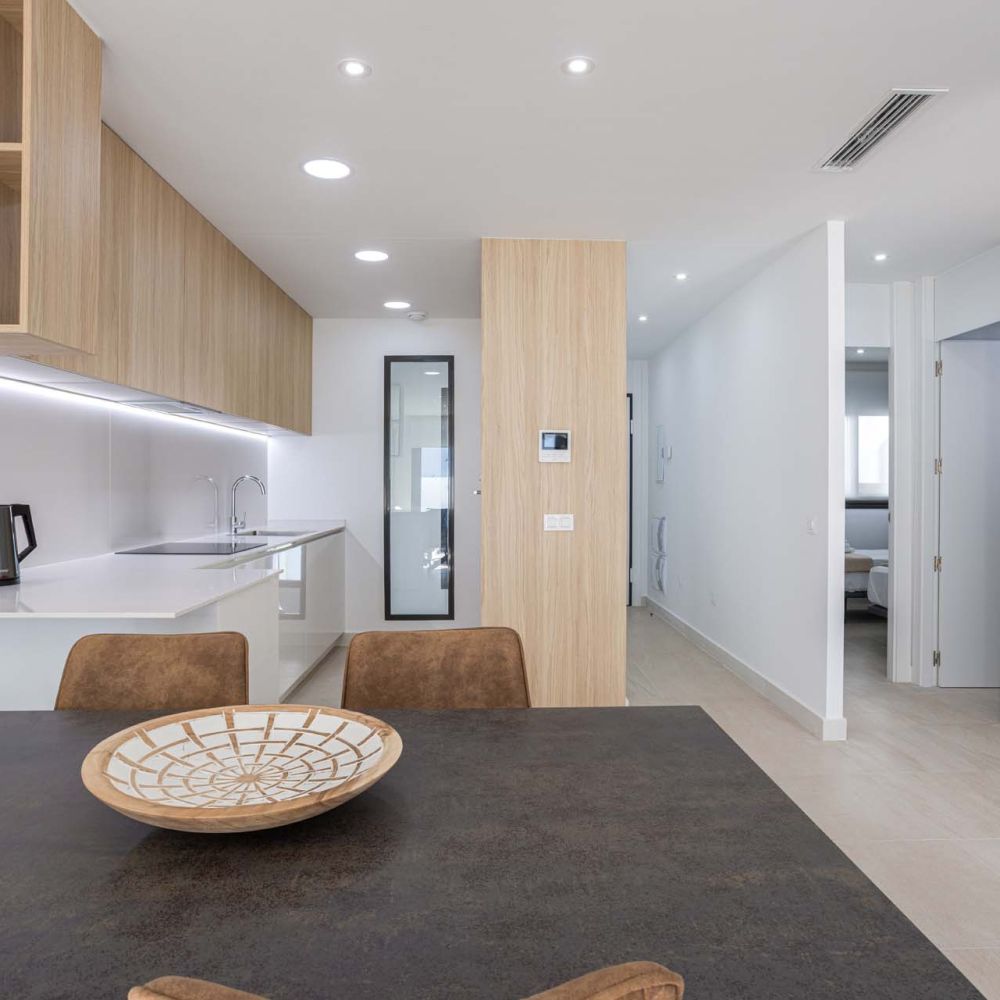 Alicante Spain 4 February 2026: Bright contemporary kitchen and dining area with wood cabinetry